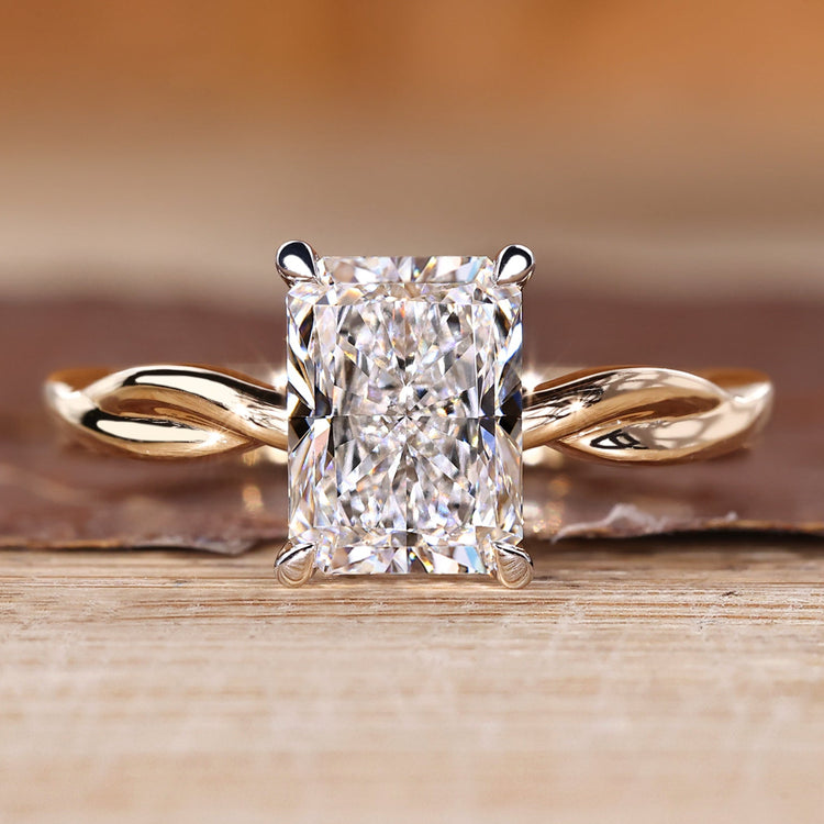 Radiant cut diamond ring with twisted shank in solitaire style.