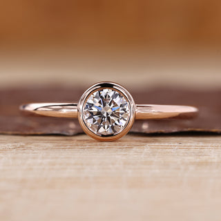 Solitaire diamond ring with round diamond in a smooth bezel setting.