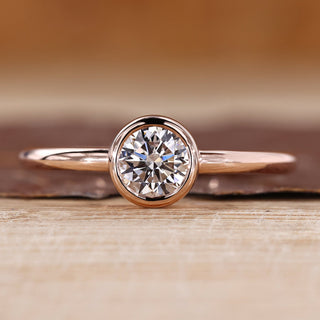 Solitaire diamond ring with round diamond in a smooth bezel setting.