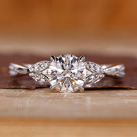 Round cut diamond ring wave split pave shank.