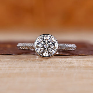Bezel diamond ring with round centre diamond.