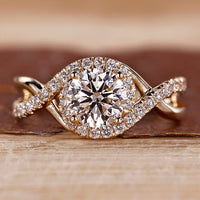 Round cut diamond ring halo twisted shank four prong.