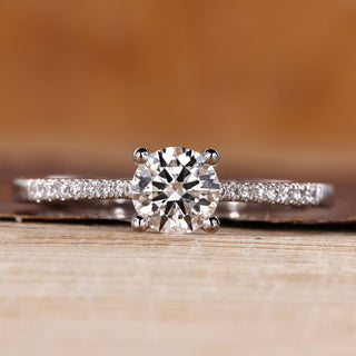 Round cut diamond ring pave tapered shank four prong.
