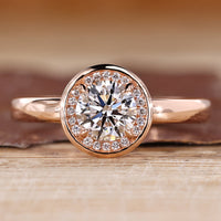 Round diamond ring halo bezel four claw prong setting.