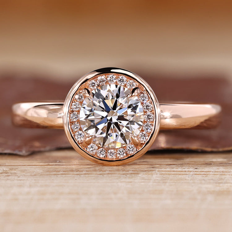 Round diamond ring halo bezel four claw prong setting.