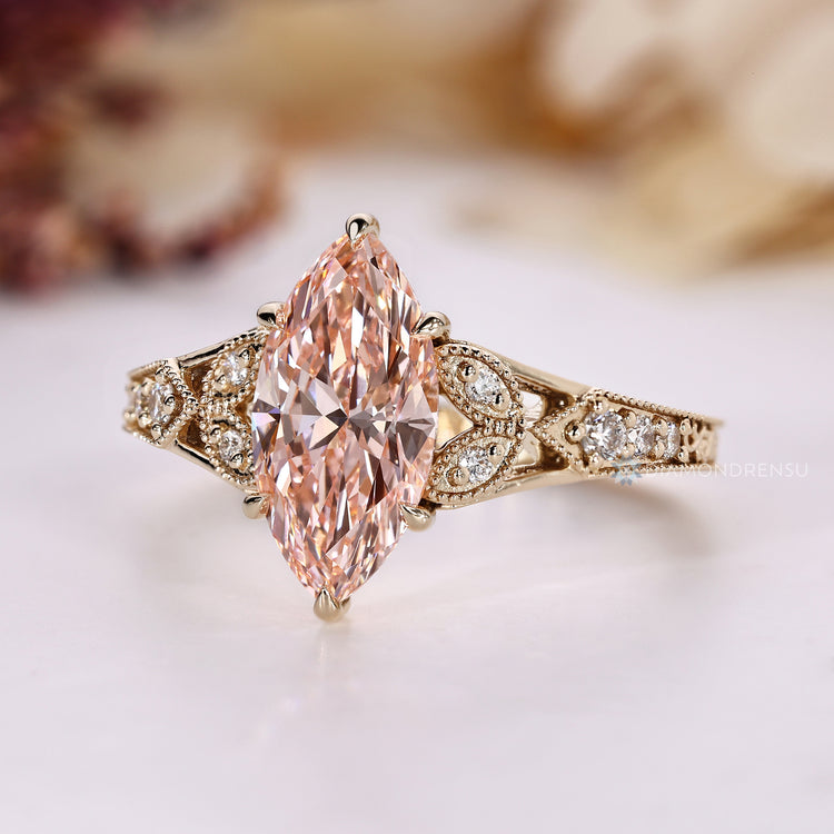 Marquise ring with milgrain detailing and round side stones.