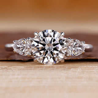 Round cut diamond ring pear side stones three stone.