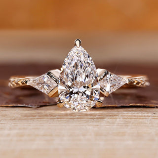 Pear cut diamond ring kite side stones art deco style.