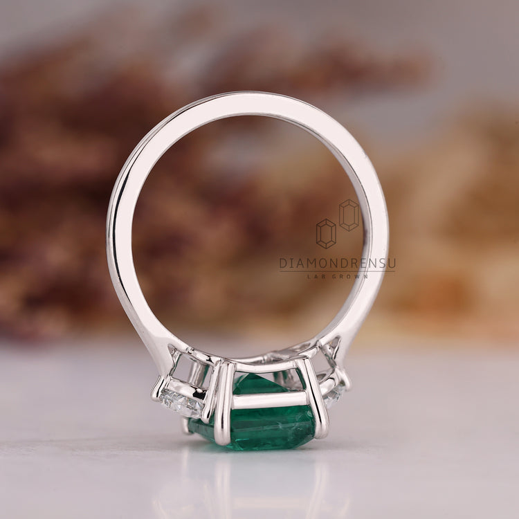 Emerald cut emerald ring tapered shank prong design.