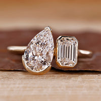 Toi et moi ring pear emerald diamond bezel prong set.