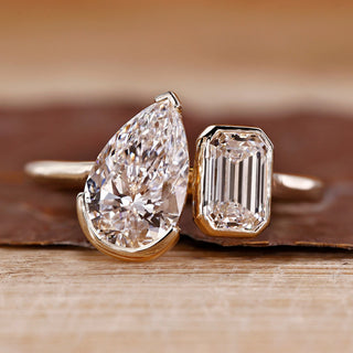Toi et moi ring pear emerald diamond bezel prong set.