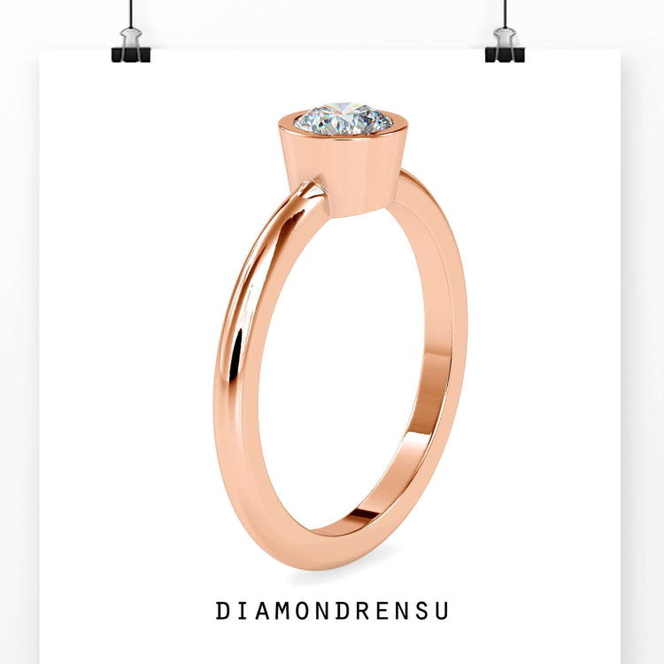 Simple diamond ring single featuring a bezel set lab grown diamond.