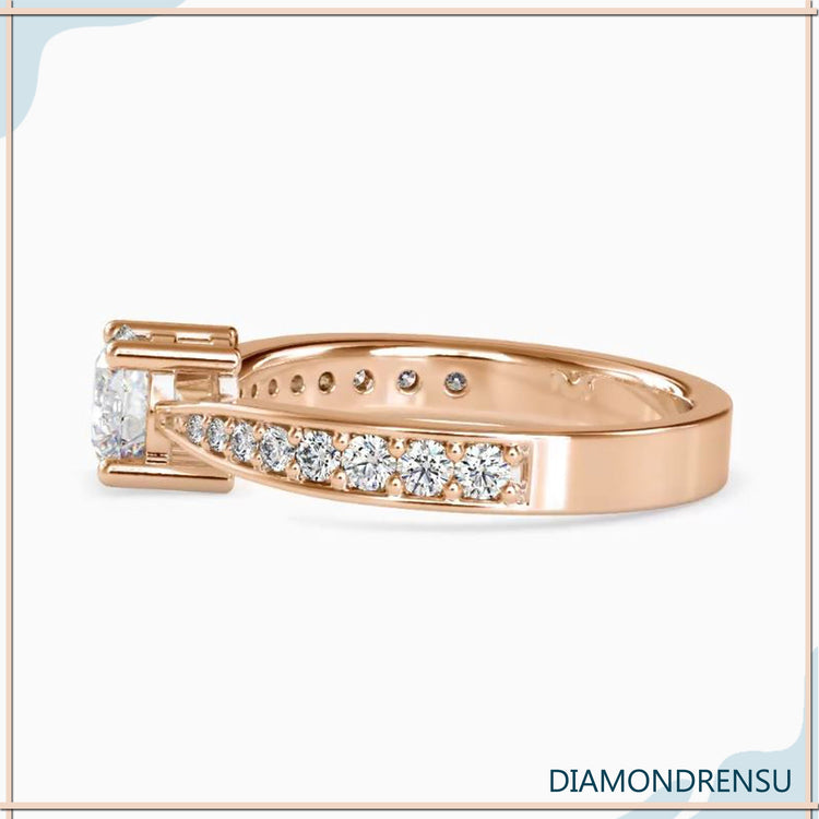 Diamondrensu engagement ring with a round cut diamond and tapered shank in a pave setting.
