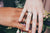 Two hands of bride and groom showing wedding rings in their right hands