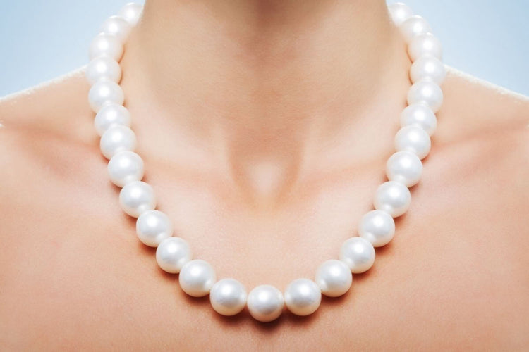 A woman wearing a high quality pearl necklace