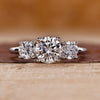 Three stone engagement ring crafted in a white gold trellis ring setting.

