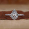 Pear halo engagement ring with round cut pave band.
