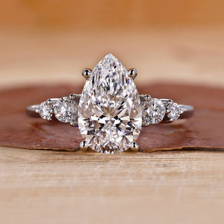 5 stone diamond ring featuring pear and round diamonds in white gold.
