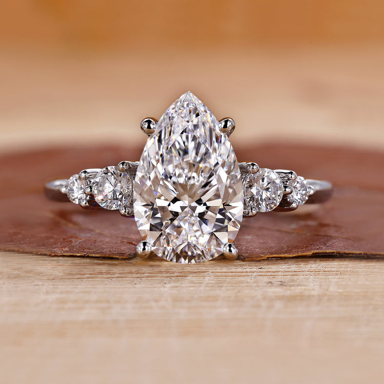 5 stone diamond ring featuring pear and round diamonds in white gold.
