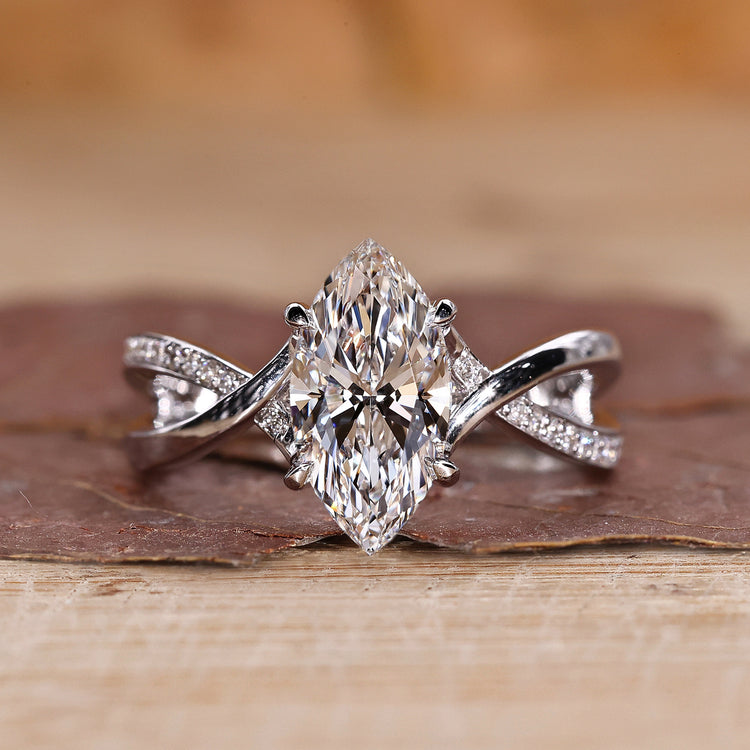 Marquise diamond ring with twisted pavé band in white gold.
