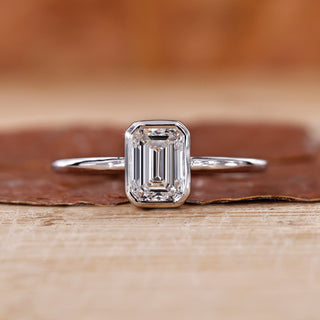 Bezel set engagement ring with emerald cut diamond ring.
