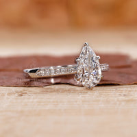 round side stones in pear cut engagement ring.
