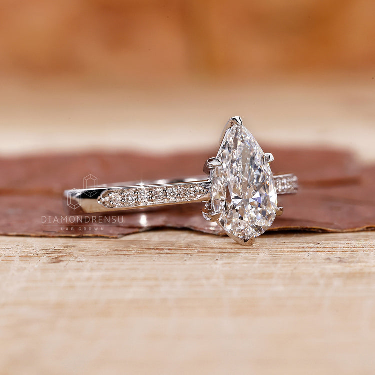 round side stones in pear cut engagement ring.
