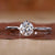 Round cut diamond solitaire engagement ring on a white background