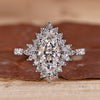 White gold engagement ring with marquise diamond and round halo.
