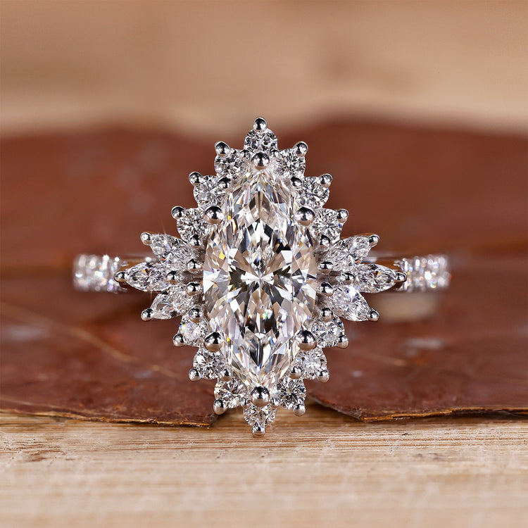 White gold engagement ring with marquise diamond and round halo.
