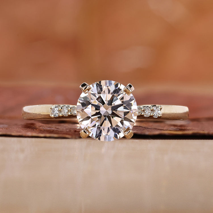 round engagement ring with yellow gold ring band.
