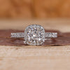Cushion cut halo engagement ring with round diamond halo in yellow gold.
