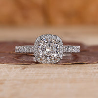 Cushion cut halo engagement ring with round diamond halo in yellow gold.
