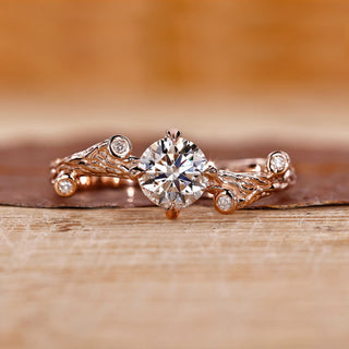 Rose gold engagement ring with round cut diamond and four claw prong setting.
