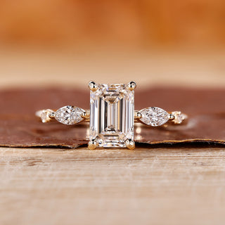 Emerald cut engagement ring with marquise and round side stone.
