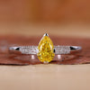 Yellow diamond pear engagement ring with pave diamond band.
