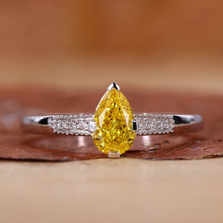 Yellow diamond pear engagement ring with pave diamond band.

