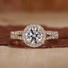 Halo diamond engagement ring in yellow gold with pavé detailing.
