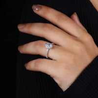 V and round prong setting with halo diamond center.
