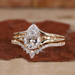 Solitaire pear shaped engagement ring with matching yellow gold wedding band.
