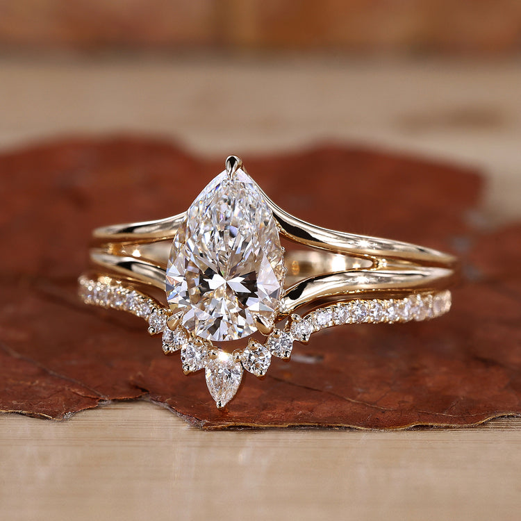 Solitaire pear shaped engagement ring with matching yellow gold wedding band.
