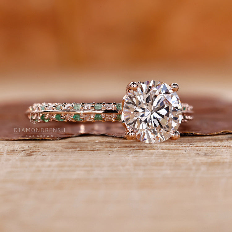 Round emerald ring with prong setting and knife edge band.
