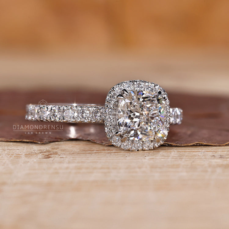 Pavé diamond ring with cushion cut centre and halo in yellow gold.
