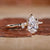 Side view of pear cut diamond ring showcasing claw prongs and miligrain design.