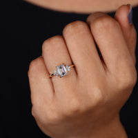 Custom muse ring with emerald center and side stones.
