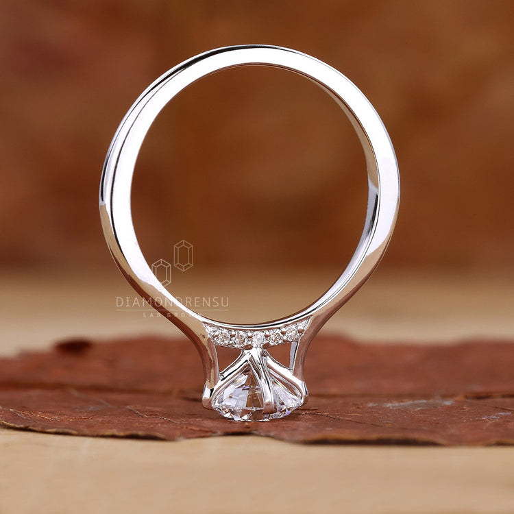 Round solitaire engagement ring featuring diamond bridge accent