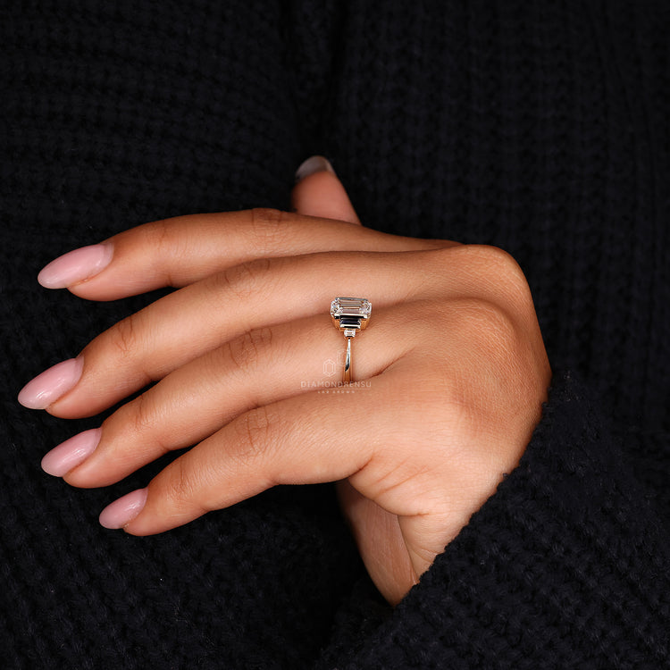 Tapered shank engagement ring with emerald and baguette cut stones.
