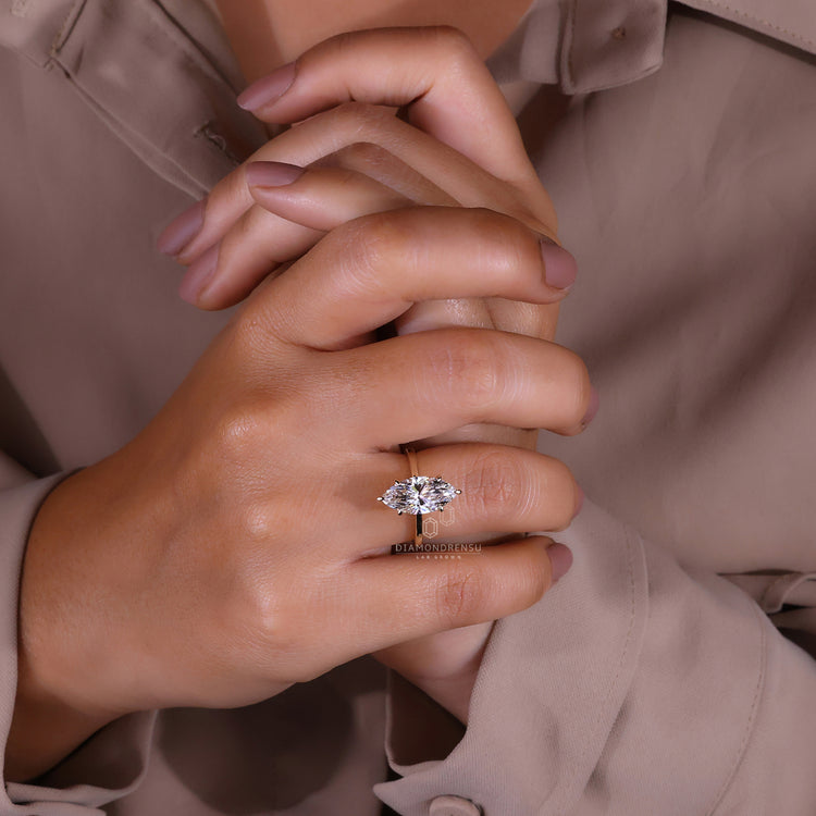 Elegant marquise solitaire ring featuring a customisable yellow gold band.
