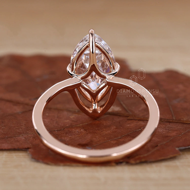 Handmade jewelry featuring a marquise diamond engagement ring in rose gold.
