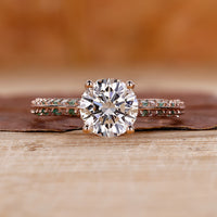 Knife edge ring with round cut diamond and pavé setting in rose gold.
